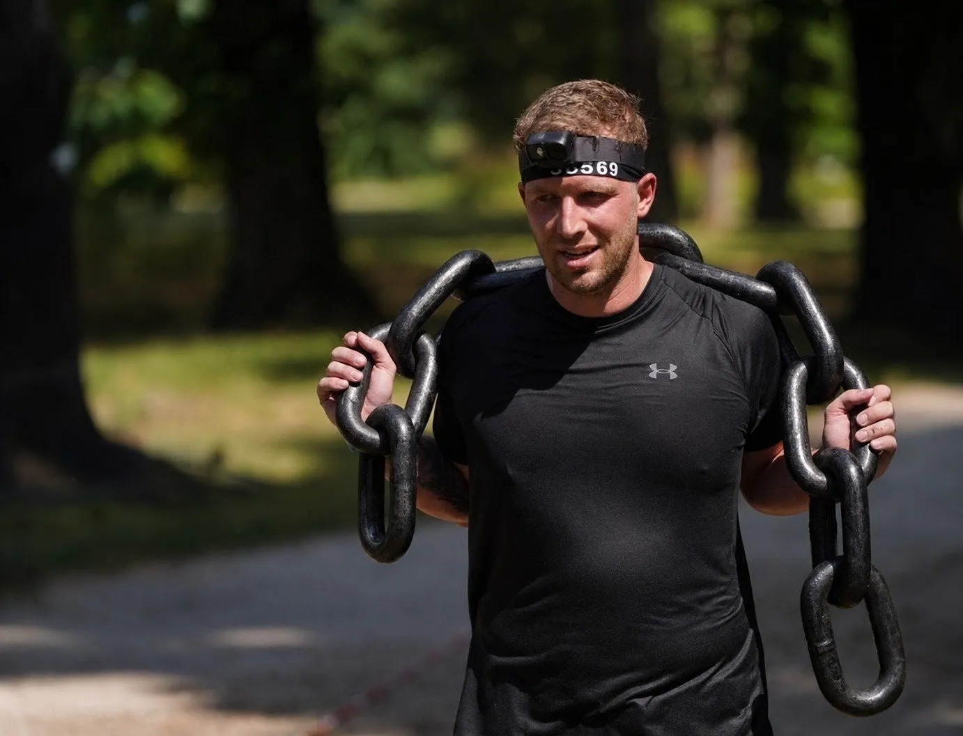 Denis carrying heavy iron chains during a Spartan Race